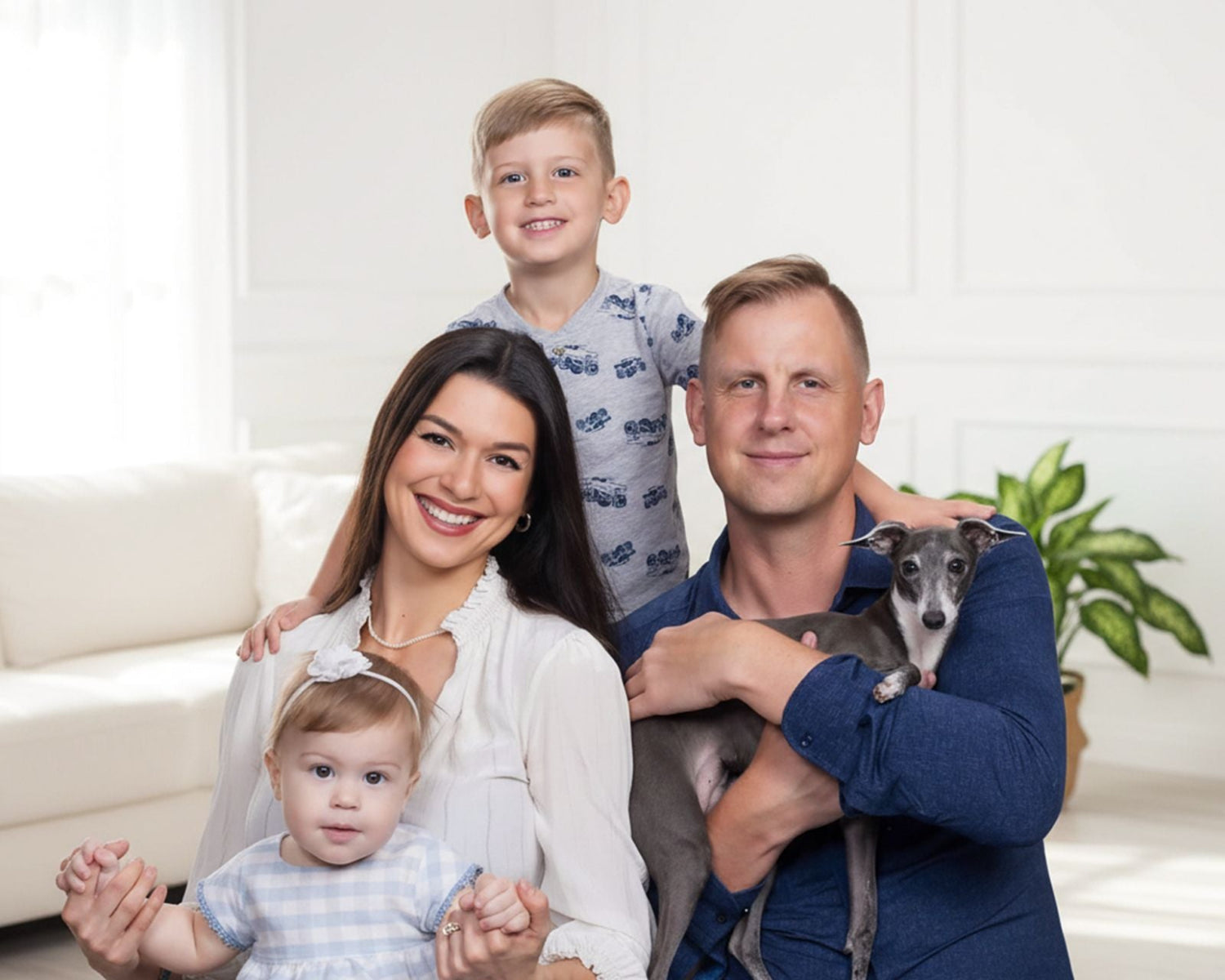 Family of four with a dog in a living room setting

